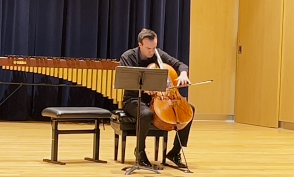 Thomas Fortner performs Connor's solo work for cello. (Thomas drags his bow with both hands across the Low C string.)